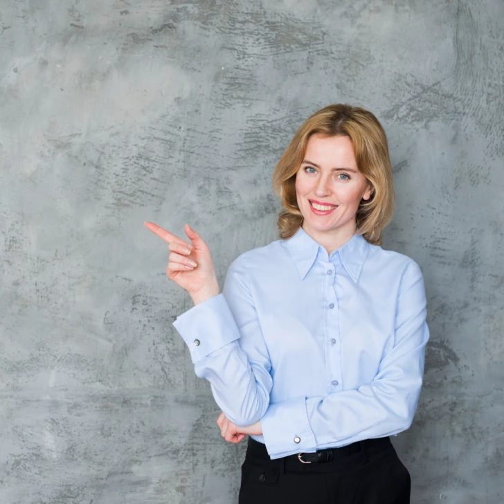 Smiling woman pointing finger to the left