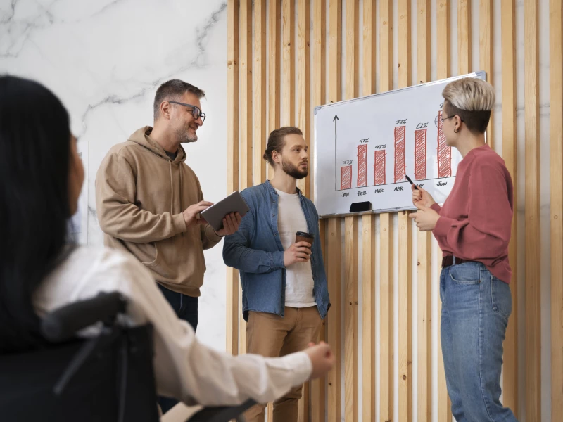 Een groep mensen is blij om betrokken te blijven via dagstarts en weekoverleggen, wat een van de voordelen is van Lean management