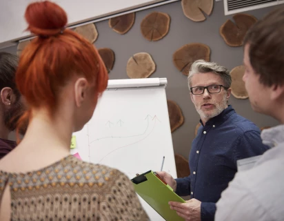 Groep mensen die resultaten analyseren op een flipover